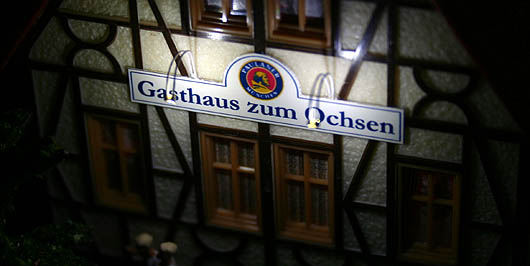 Beleuchtetes Schild des Gasthauses bei Nacht